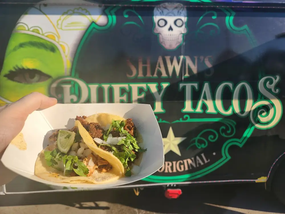 Two small tacos in front of a taco truck